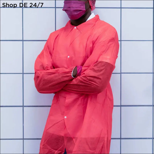 Eine person trägt einen nitras pp-besuchermantel in rot aus langlebigem material mit knöpfen und handschuhen für professionelle und hygienische umgebungen