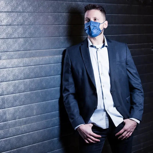 Ein mann trägt eine blaue nitras soft protect plus gesichtsmaske soft protect plus 4-lagig marienblau