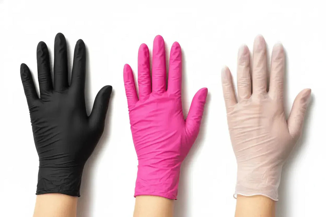 Drei einmalhandschuhe in schwarz, pink und beige aus latex und nitril liegen flach auf weißem hintergrund