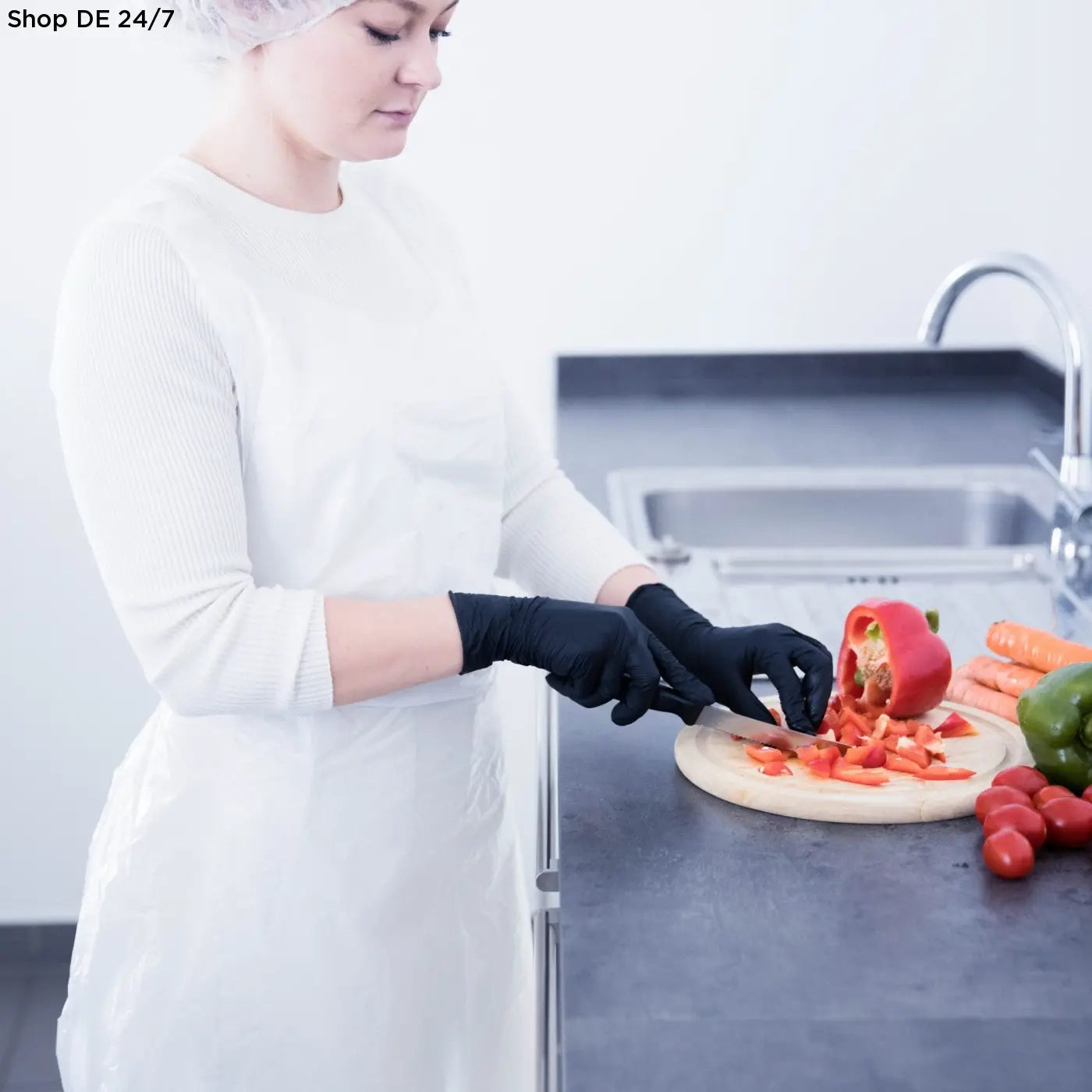 Eine frau mit weißen astronautenhauben 2 lagig und farbigen einmalhandschuhen bietet zuverlässigen schutz in deutscher qualität