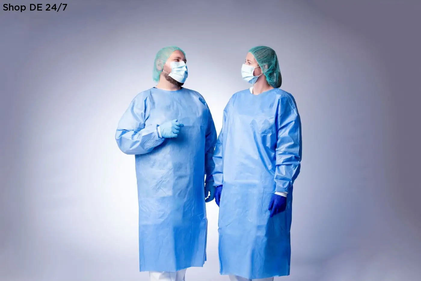 Zwei medizinische fachkräfte tragen blaue chirurgische kleidungen und nitras indigo wave nitril-einmalhandschuhe mit mikrogeraute fingerspitzen für anspruchsvolle umgebungen