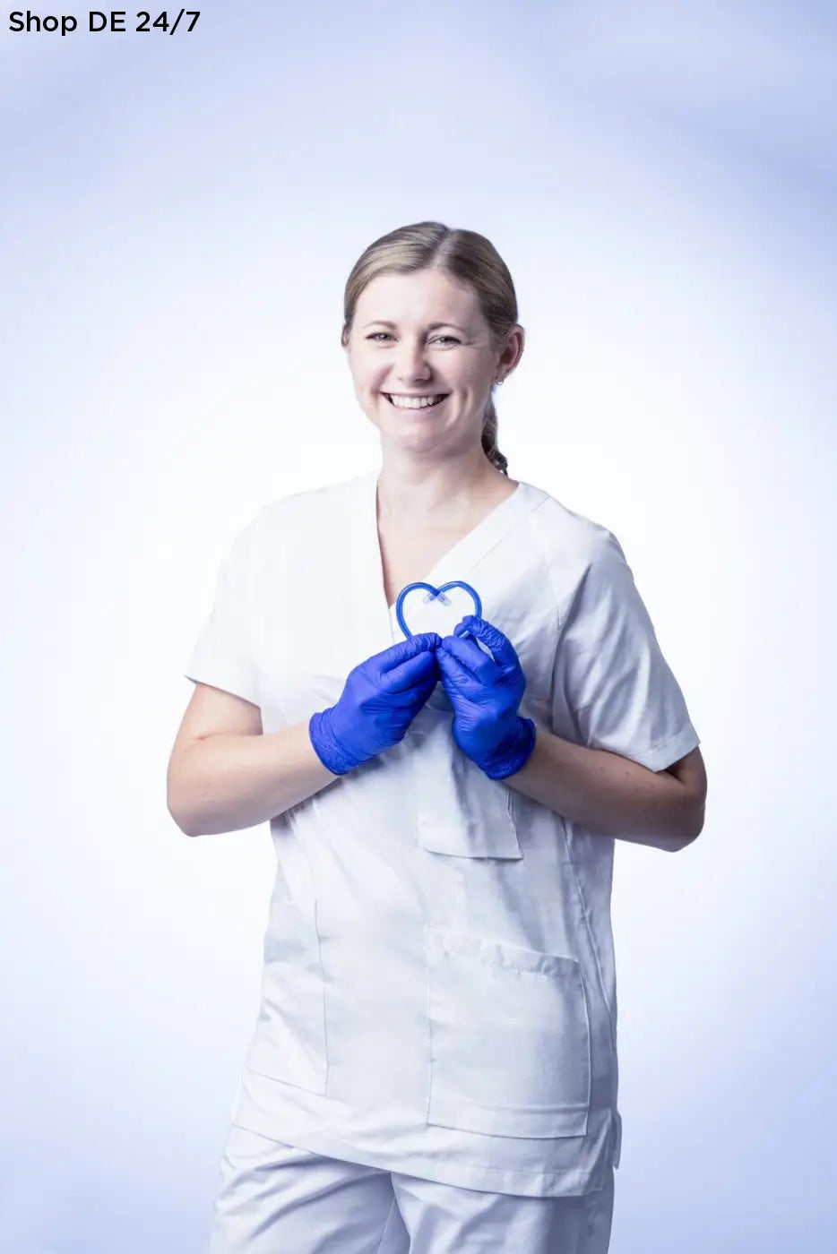 Frau in weißen nitras indigo wave nitril-einmalhandschuhen mit mikrogeraute fingerspitzen hält herzförmiges object