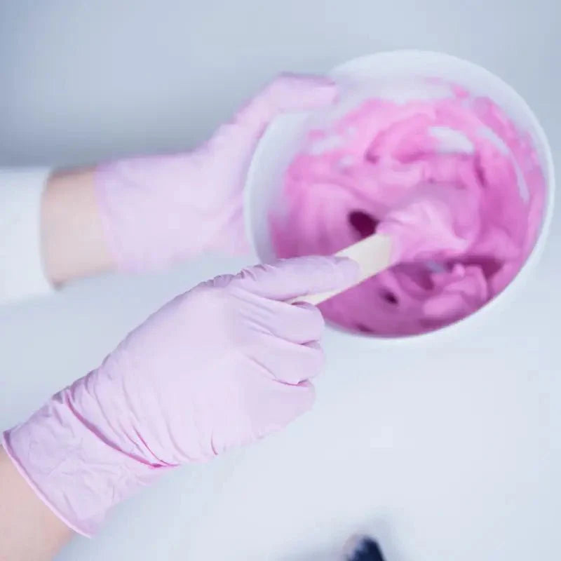 Rosa nitril-einmalhandschuhe nitras pink wave mit mikrogeraute fingerspitzen beim rühren von pinker slime in weißer schüssel