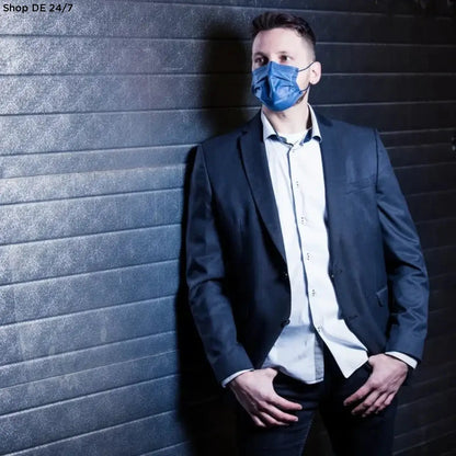 Ein mann trägt eine blaue nitras soft protect plus gesichtsmaske soft protect plus 4-lagig marienblau